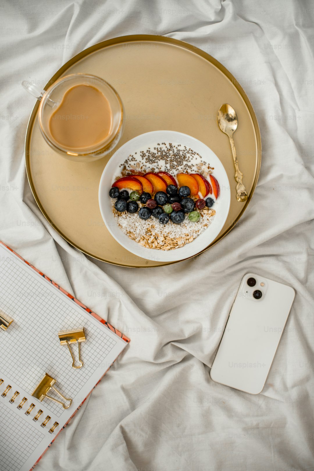 Notebook, tea, and healthy meal arranged on a light table to suggest a calm gut-health reading hub.