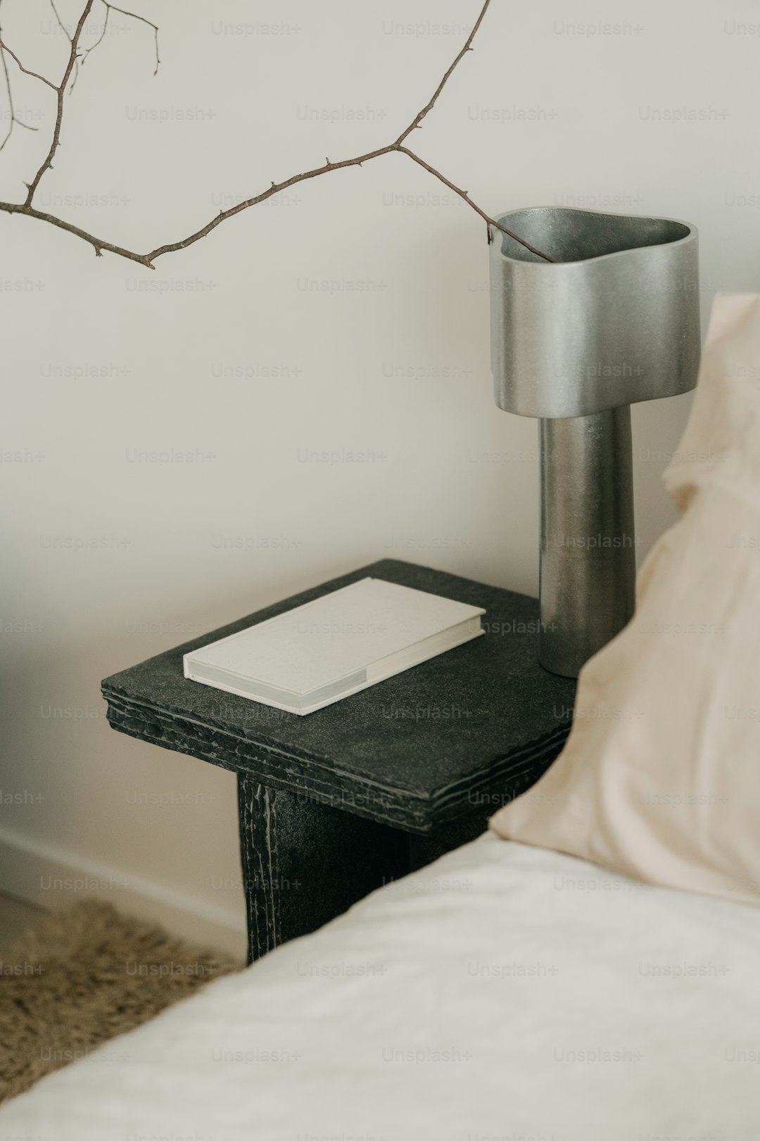 Bedside table with a glass of water, book, and dim lamp in a calm nighttime setting.