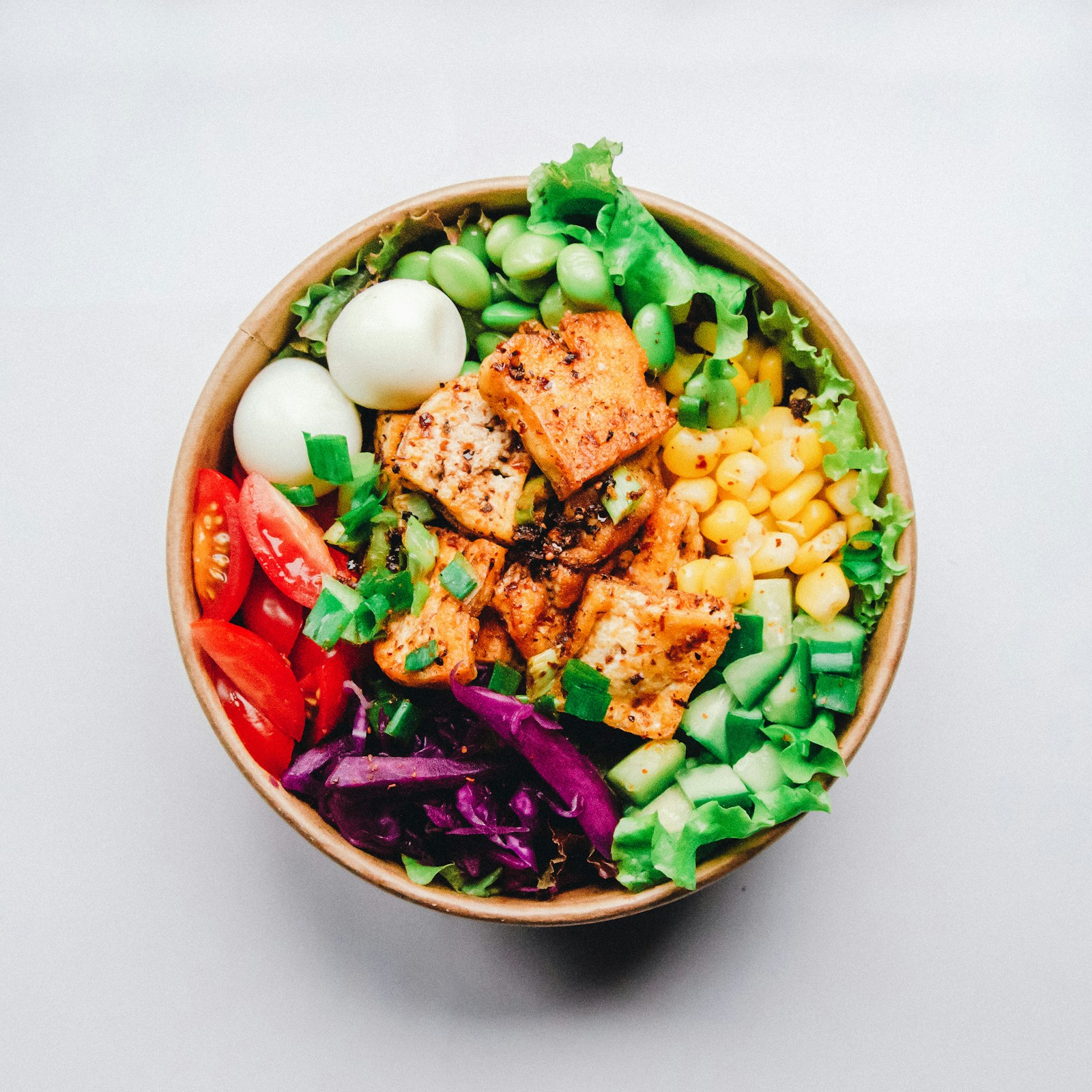 Bowl of colorful salad with vegetables and grains, representing varied, personalized eating patterns.