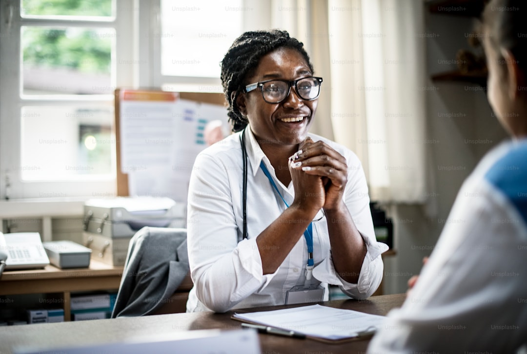 Doctor reviewing notes with a patient in a bright clinic setting.
