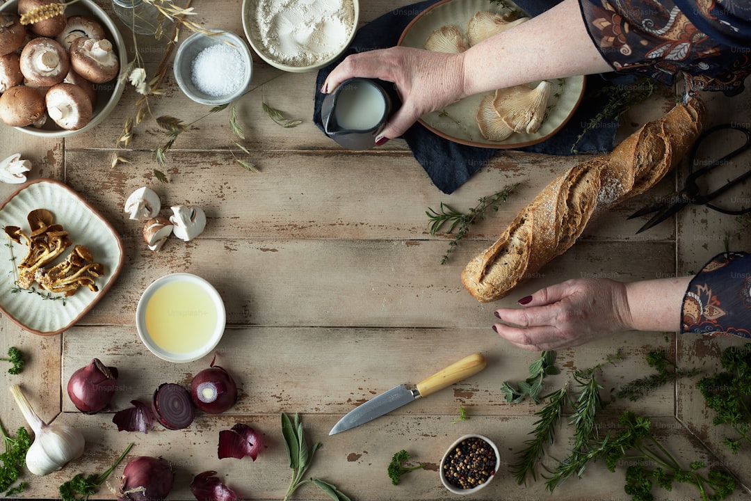 Garlic bulbs, sliced onion, and bread arranged on a kitchen board.